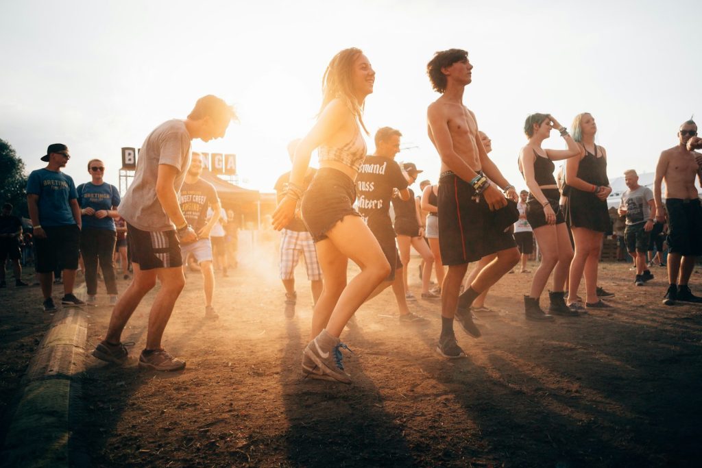 Ludzie tańczący podczas zachodu słońca na festiwalu myzycznym.