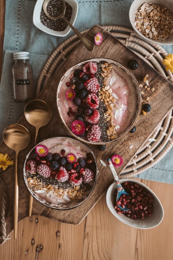 Dieta wegańska: smoothie bowl z owocami: malinami, borówkami i orzechami.